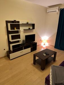 a living room with a tv and a coffee table at Clarissa apartment City Kvart in Podgorica