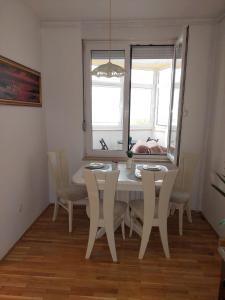 uma sala de jantar com uma mesa branca e cadeiras em Apartman Buba em Krapinske Toplice