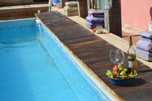 a bowl of fruit and a bottle of wine next to a swimming pool at Quiet place 3 km from caesarea in Or ‘Aqīvāh