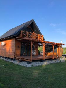 uma grande cabana de madeira com um telhado de gambrel em Domek na roztoczu em Tomaszów Lubelski