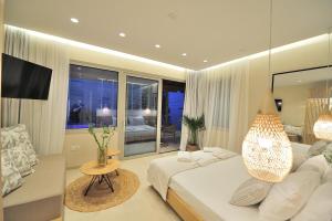 a bedroom with a large bed and a living room at Salty Wave Suites in Skiathos
