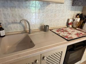 a kitchen sink with a faucet in a kitchen at Appartamento vista Monte Rosa, giardino in Residence Walser a 10minuti da Macugnaga - MONTEROSAFLAT in Vanzone