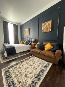 una camera con letto e divano di Le Grand Berger Chambres D'Hotes 