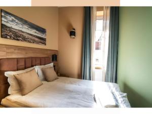 una camera da letto con un grande letto con lenzuola bianche e una finestra di MARIENSZTAT 8 Apartments a Varsavia