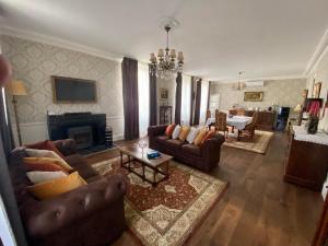 una gran sala de estar con sofás y chimenea. en Le Grand Berger Chambres D'Hotes 