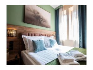 a bedroom with a bed with two towels on it at MARIENSZTAT 8 Apartments in Warsaw