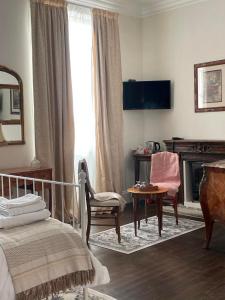 a bedroom with a bed and a table and a chair at Le Grand Berger Chambres D'Hotes 