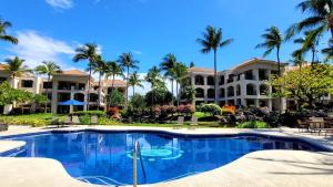 um resort com piscina e palmeiras em The Shores at Waikoloa 231 em Waikoloa
