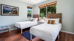twee bedden in een kamer met een raam bij Mauna Lani Fairways 1601 in Waikoloa +40 foto's