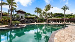 een zwembad in een resort met palmbomen bij Mauna Lani Fairways 1601 in Waikoloa