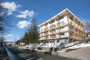 a tall white building on the side of a street at VIP Apartamenty Jagiellonska 33a in Zakopane