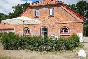 a brick building with an umbrella in front of it at Försterei in Barkelsby
