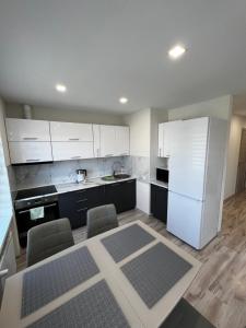 a kitchen with white cabinets and a white refrigerator at A place to take a rest. in Tukums