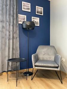 a room with a chair and a lamp and a table at B2B Apartments in Jihlava
