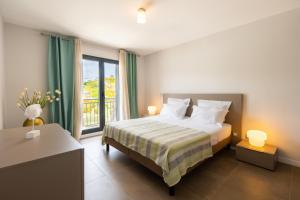 um quarto com uma cama e uma grande janela em Appart Florida Mer 3ch Luxe em Schœlcher