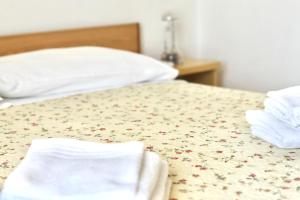 a bed with white towels and flowers on it at Appartamento vista mare in Porto Recanati