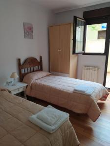 a bedroom with two beds and a window at La Gaviota in Comillas