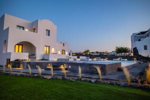 a villa with a swimming pool at night at Bonsai Luxury Suites in Karterados