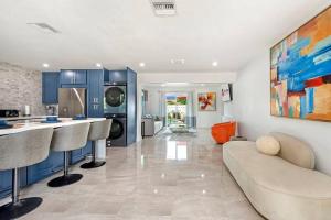 cocina y sala de estar con armarios azules y sofá en Sun-Kissed Bliss: Dreamy Getaway en West Palm Beach