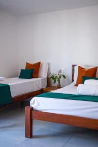 dos camas sentadas una al lado de la otra en una habitación en Pousada Enero, en Maragogi