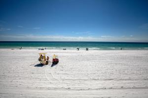 dos carros en una playa con el océano en el fondo en Beachside I by Panhandle Getaways, en Destin