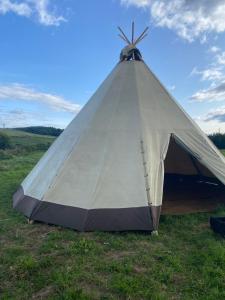 a tent sitting in the grass in a field at Devon Tipi Camp And Glamp in Stoke Canon