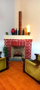 sala de estar con chimenea de ladrillo y 2 sillas en Hostel Paraíso en San Rafael