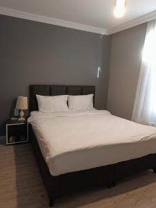 1 dormitorio con 1 cama grande con sábanas y almohadas blancas en Ore Pera Suites en Estambul