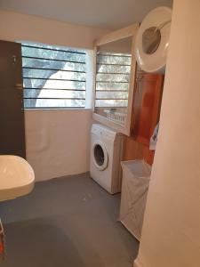 a laundry room with a washing machine and a window at Petrohori before midnight in Pylos