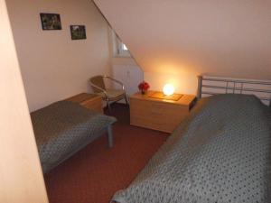 a bedroom with two beds and a table with a lamp at DUeNENHOF-10 in Olsdorf