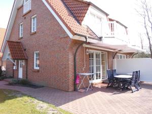 a brick house with a table and chairs on a patio at Jan-und-Gret-6 in Olsdorf