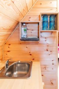 a kitchen with a sink in a tiny house at Au pied du frêne in Herzeele