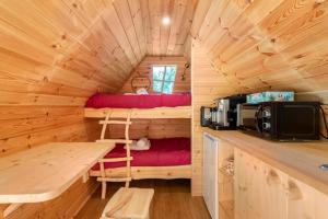 a log cabin with a desk and a bed in it at Au pied du frêne in Herzeele