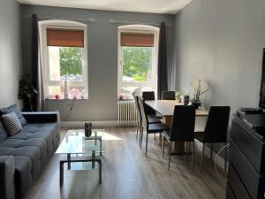 a living room with a couch and a table and chairs at Stadtnah an der Förde 7 1OG R in Flensburg