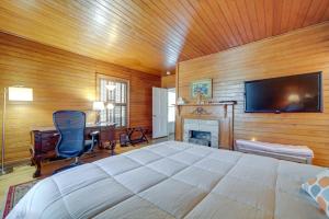 um quarto com uma cama, uma televisão e uma secretária em Maggie Valley Historic Farmhouse on 5 Acres! em Maggie Valley