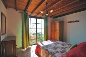 ein Schlafzimmer mit einem Bett und einem großen Fenster in der Unterkunft Las Palmeras C in Arecida