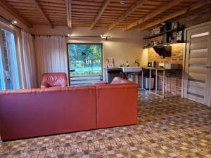 Holiday house Elsa Linden : غرفة معيشة مع أريكة حمراء ومطبخ