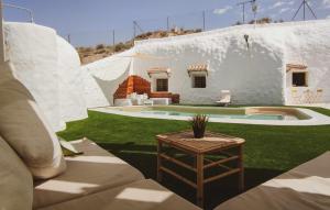 a white house with a table in front of it at Cueva OTTO Familiar Privada in Baza