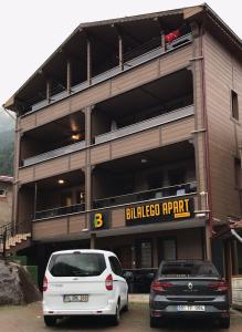 twee auto's geparkeerd op een parkeerplaats voor een gebouw bij Uzungöl Bilalego Apart in Uzungol