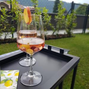 a glass of wine and an orange on a table at Ferienwohnung Karasek Deluxe in Sattendorf