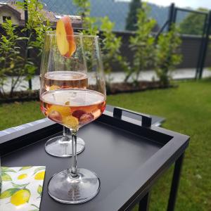un bicchiere di vino e un'arancia su un tavolo di Ferienwohnung Karasek Deluxe a Sattendorf