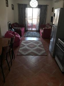 uma sala de estar com um sofá e uma cozinha em Porto Golf Marina New Alamein Chalet em El Alamein