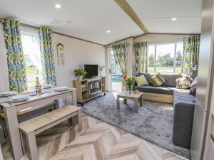 a living room with a couch and a tv at Jean's Place in Ganton