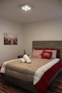 a bedroom with a large bed with red and white pillows at Luxury Vacation House in Miami’s Center! in Miami