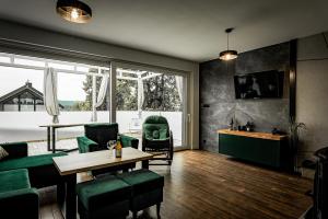 a living room with a table and green chairs at Domy na Roztoczu Aleja Lipowa A H in Zwierzyniec