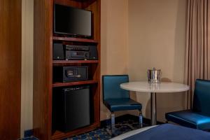 een kamer met een tafel en twee stoelen en een televisie bij Harborside Inn in Boston