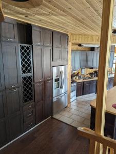 cocina con armarios de madera y nevera de acero inoxidable en Sundance Country Lodge B&B en Marlboro
