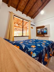 Schlafzimmer mit blauer Decke auf einem Bett in der Unterkunft Cabaña de Elsa in Olón