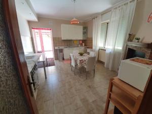 Casa dei Nonni في Roccascalegna: مطبخ وغرفة طعام مع طاولة وكراسي