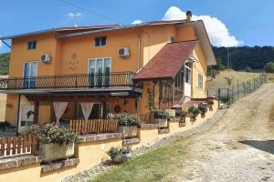 Casa dei Nonni في Roccascalegna: أمامه بيت كبير فيه نباتات الفخار